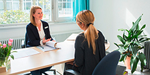 Zwei Frauen sitzen im Beratungsgespräch einander gegenüber