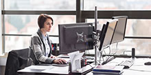 Eine Frau sitzt an ihrem Schreibtisch im Büro.