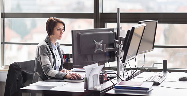 Eine Frau sitzt an ihrem Schreibtisch im Büro.