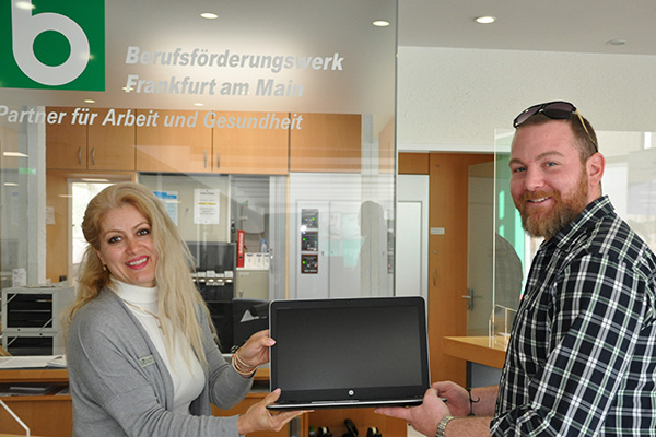 Eine Frau und ein Mann stehen vor der Rezeption des BFW-Frankfurt und halten ein Tablet in den Händen.