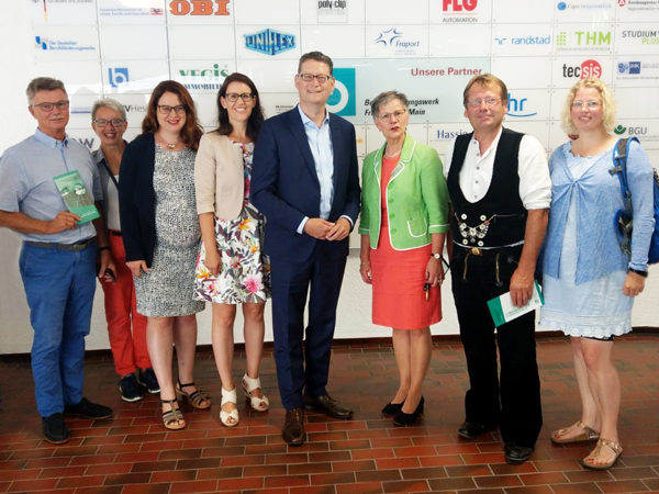 Ein Gruppenbild mehrerer Personen, welche einem höhreren Anlass gekleidet sind.