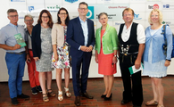 Ein Gruppenbild mehrerer Personen, welche einem höhreren Anlass gekleidet sind.